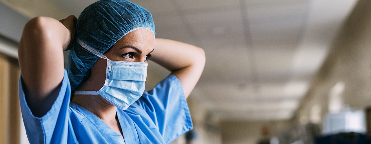 Caregiver tying surgical mask Caregiver tying surgical mask