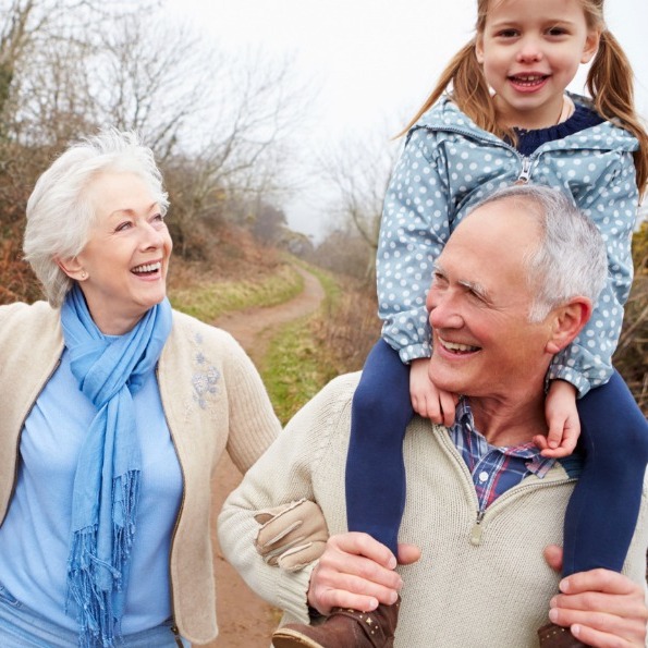 Grandparents and Granddaughter Young girl riding on grandfather's shoulders