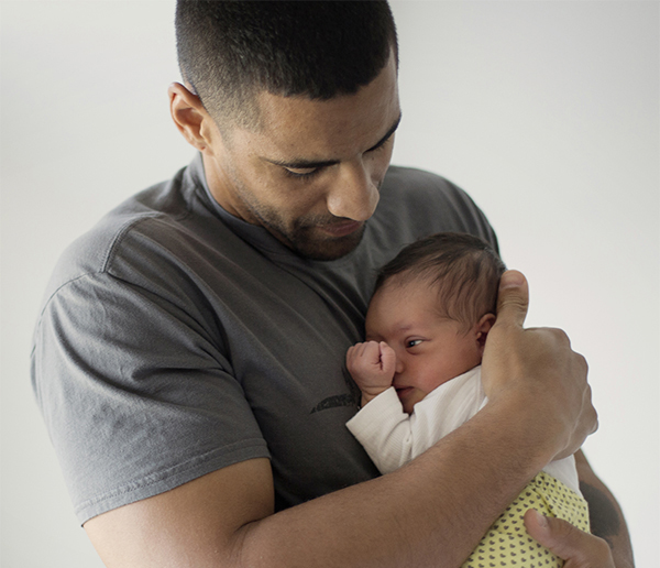 Dad and Baby Father cradling newborn baby
