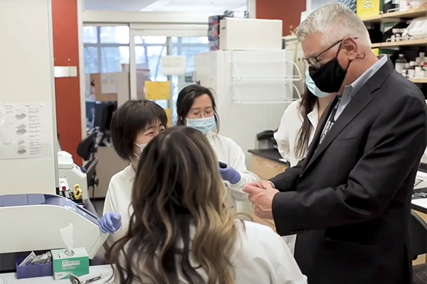 Dr. Urba talks with researchers in lab