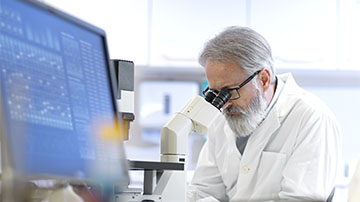Researcher looking in microscope