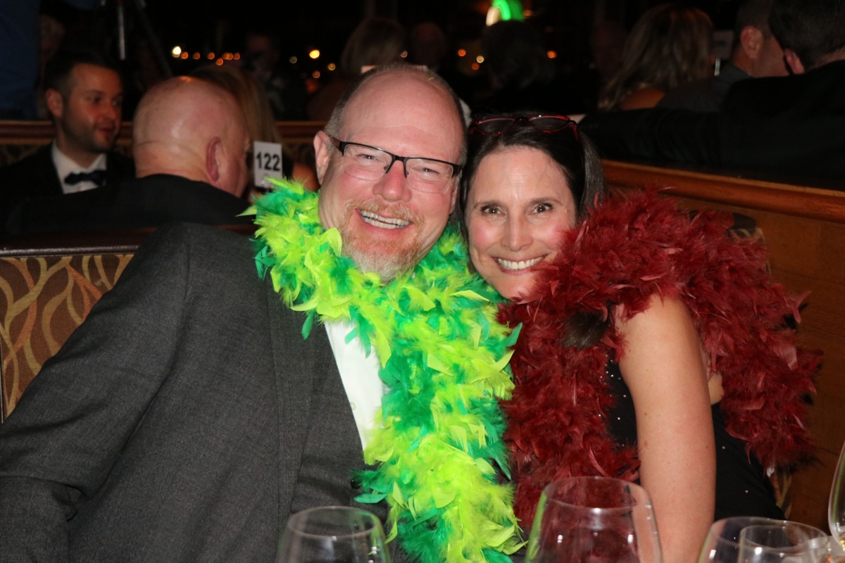 Man and woman wearing feather boas