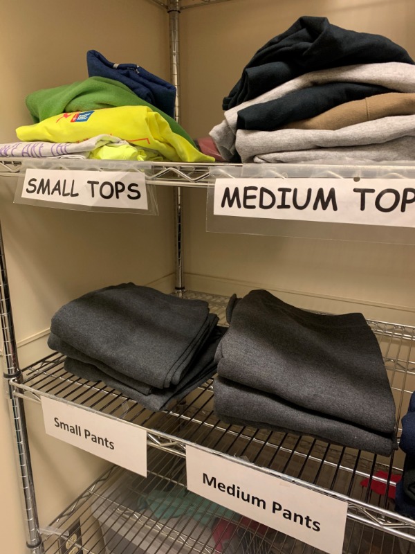 Shelf full of t-shirts, pants, and sweatshirts