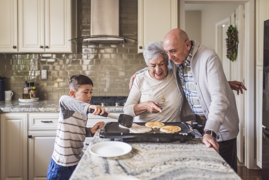 Grandparents & Grandson Grandparents watch grandson flip pancakes