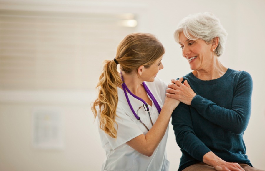 f9d7f358-f2a8-4e5e-a37b-6cd3188c2dda Caregiver resting hand on patient's shoulder