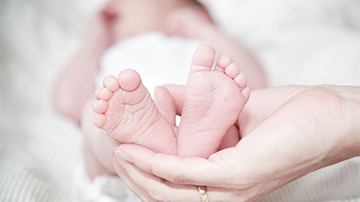 Mom's hands holding baby's feet