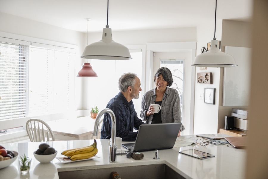 Man and woman at breakfast bar with laptop
