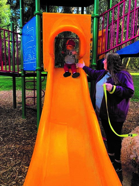 Melissa Hansen helps grandson Eli on a slide