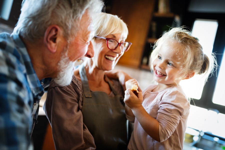 Planned Giving Smiling grandparents holding smiling granddaughter