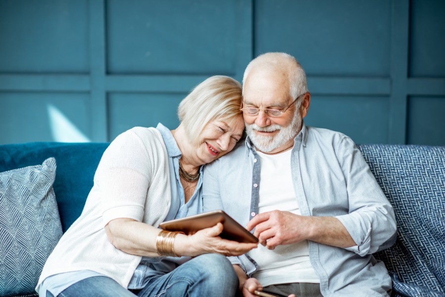 Elderly couple looks at tablet device