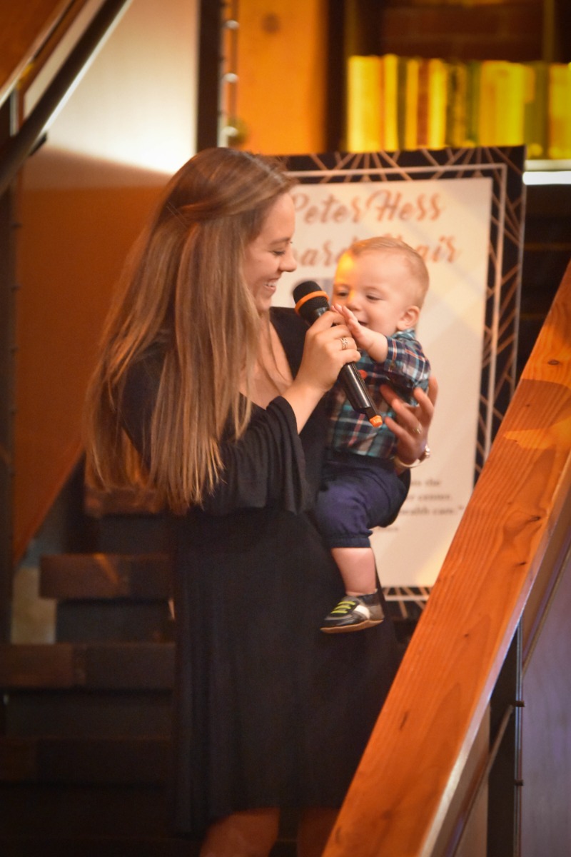 Woman holding baby who is reaching for microphone