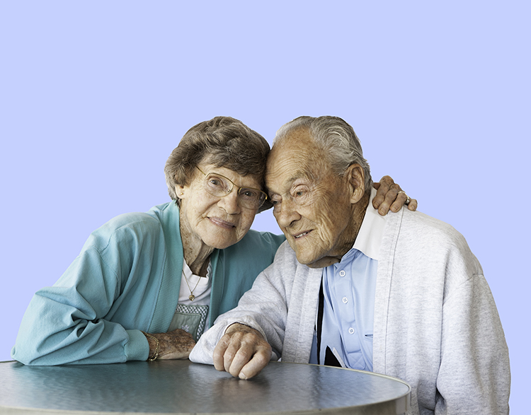 Elderly woman embraces elderly man