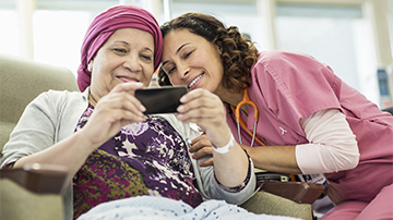 Caregiver and cancer patient looking at mobile phone