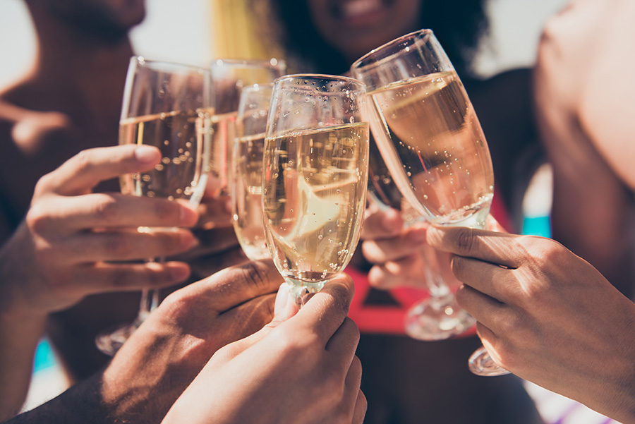 Champagne Filled champagne glasses clinking together.