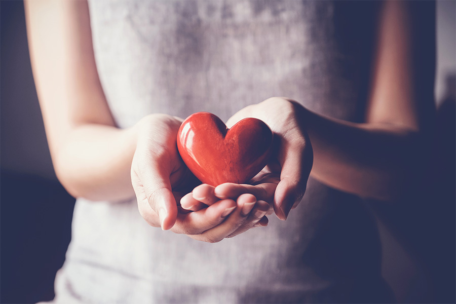 Matching Gifts Woman's hands holding ceramic heart.
